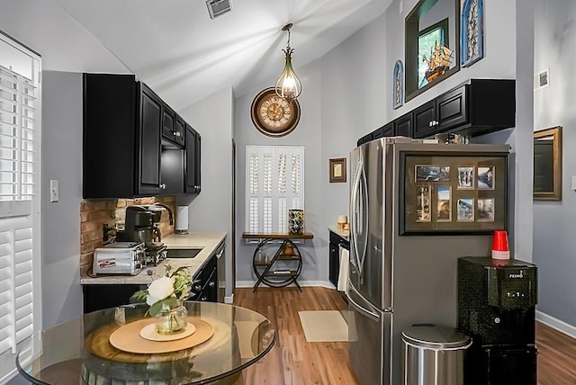 7886 Racquet Rd, North Charleston, SC 29418 - kitchen featuring dark cabinets, appliances with stainless steel finishes, wood finished floors, tasteful backsplash, and lofted ceiling