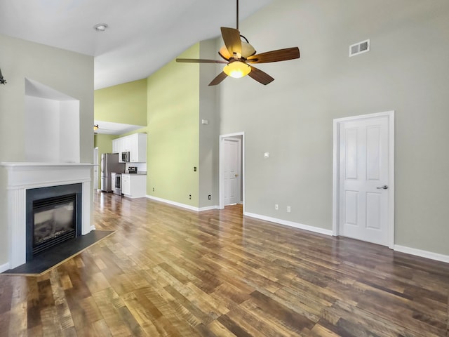 unfurnished living room with wood-type flooring, ceiling fan, and high vaulted ceiling