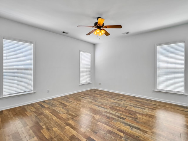 spare room featuring a healthy amount of sunlight, hardwood / wood-style floors, and ceiling fan