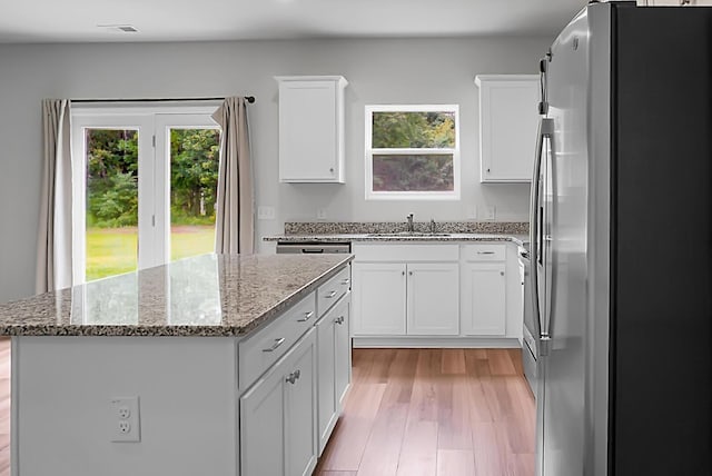 717 Butter Rd, Bonneau, SC 29431 - kitchen with stainless steel fridge with ice dispenser, a center island, light stone counters, and white cabinetry