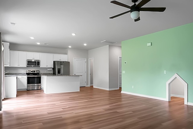 717 Butter Rd, Bonneau, SC 29431 - kitchen with appliances with stainless steel finishes, open floor plan, ceiling fan, light wood-type flooring, and white cabinets