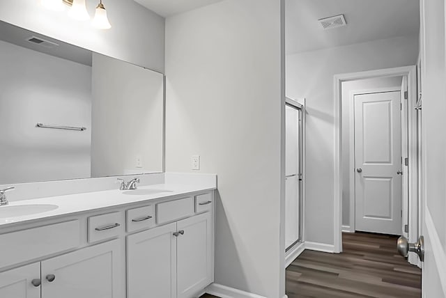 717 Butter Rd, Bonneau, SC 29431 - bathroom featuring double vanity, wood finished floors, and a stall shower