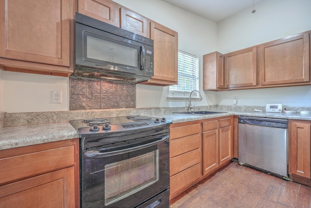 kitchen with wood-type flooring, sink, and black appliances