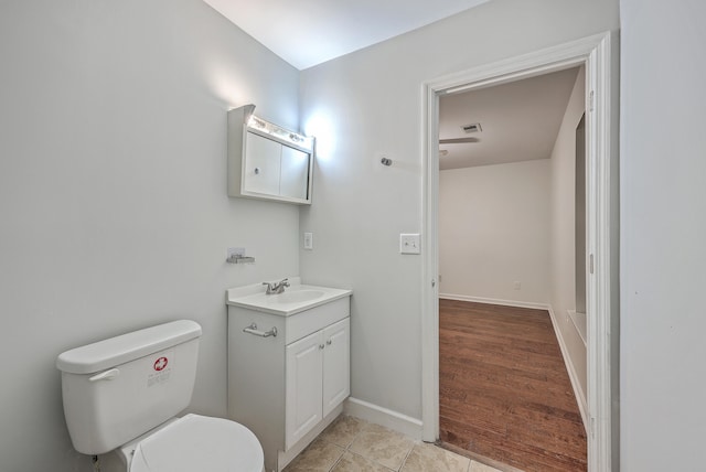 bathroom with hardwood / wood-style floors, vanity, and toilet