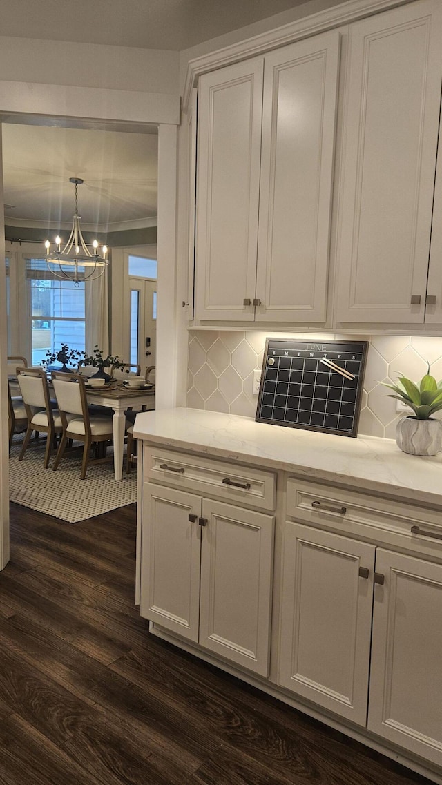 kitchen featuring a notable chandelier, white cabinets, and dark wood-style flooring