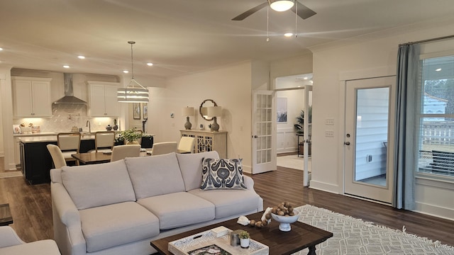 living area featuring recessed lighting, crown molding, a ceiling fan, and dark wood-style flooring