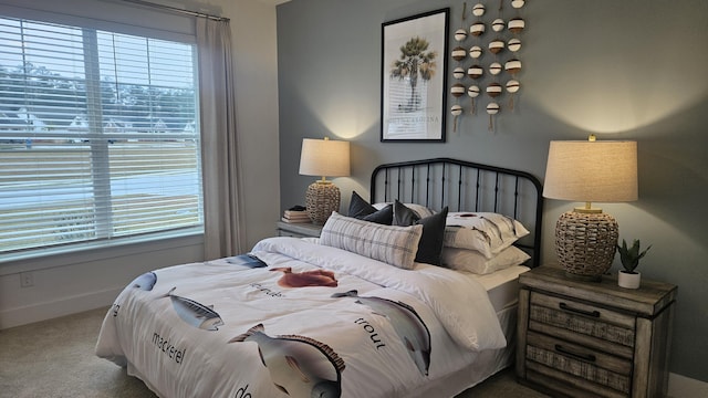 carpeted bedroom featuring multiple windows and baseboards