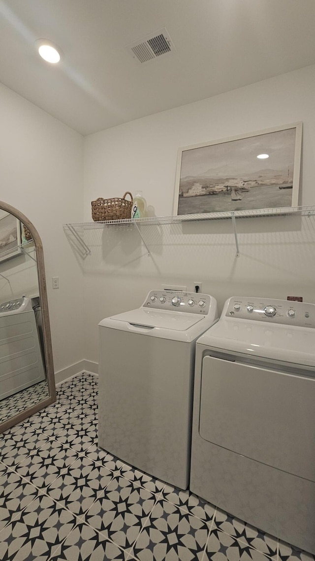 laundry area featuring visible vents, baseboards, washing machine and dryer, and laundry area