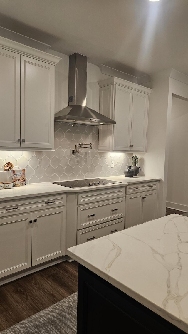 kitchen with backsplash, wall chimney range hood, dark wood finished floors, white cabinetry, and black electric cooktop