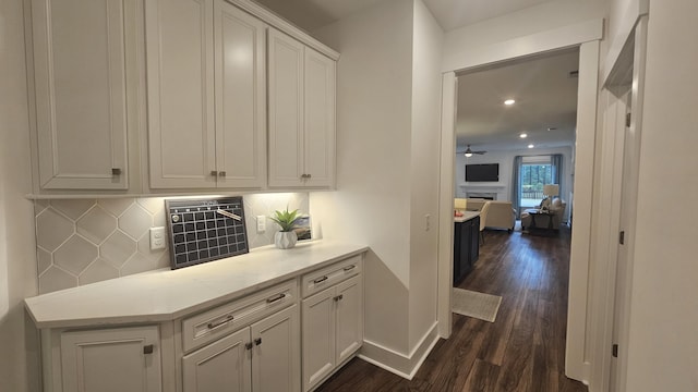 corridor featuring recessed lighting, dark wood-style floors, and baseboards