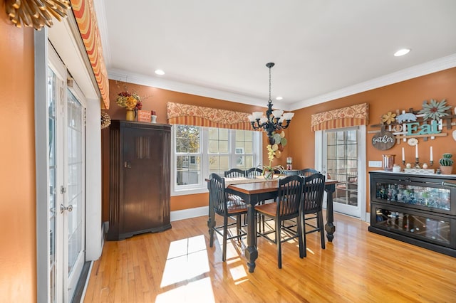 dining space with a notable chandelier, crown molding, recessed lighting, light wood-type flooring, and baseboards