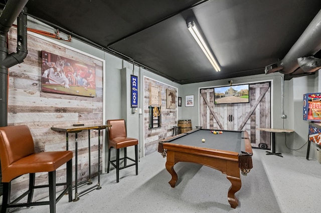 recreation room with wood walls and billiards