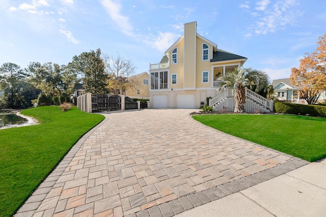 view of front facade featuring a garage, a front yard, decorative driveway, and stairs