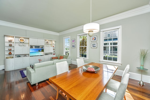 dining space featuring baseboards, crown molding, and wood finished floors