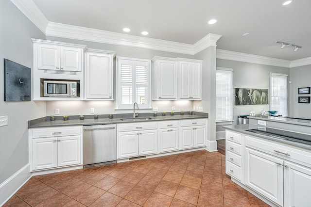 kitchen with stainless steel appliances, ornamental molding, a sink, and white cabinetry