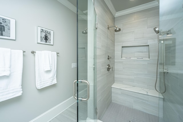 bathroom with a stall shower, crown molding, and baseboards