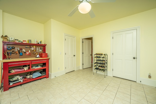 interior space with tile patterned flooring, baseboards, and a ceiling fan