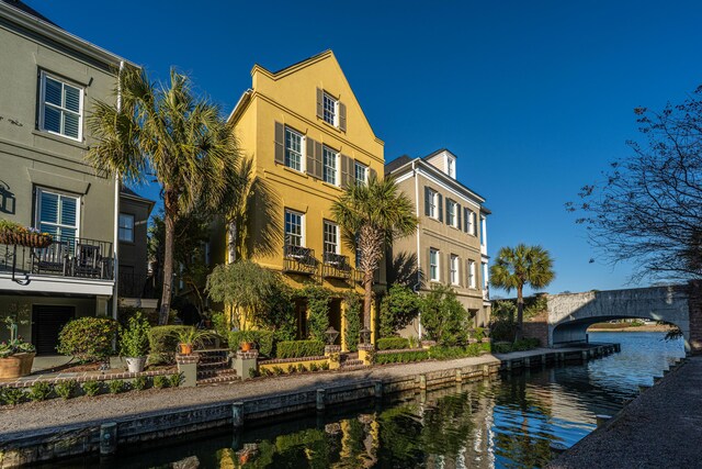 back of house featuring a water view and stucco siding