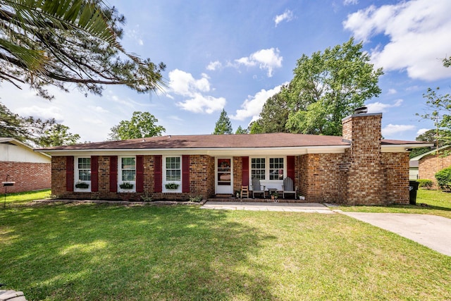 ranch-style home with brick siding, a front lawn, and a chimney