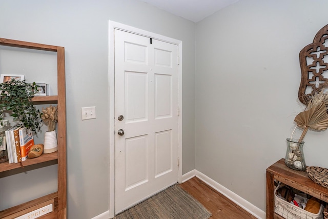 entryway featuring baseboards and wood finished floors