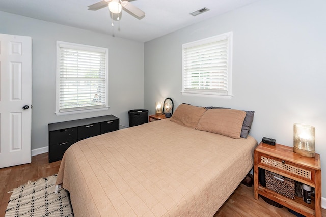 bedroom featuring ceiling fan, visible vents, and wood finished floors
