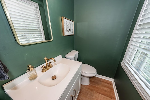 bathroom featuring vanity, baseboards, toilet, and wood finished floors