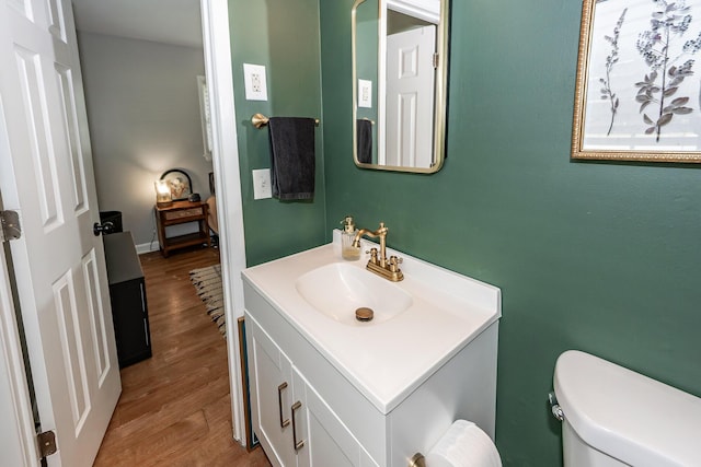 bathroom featuring vanity, wood finished floors, and toilet