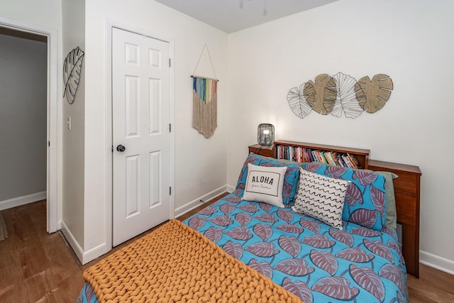 bedroom with baseboards and wood finished floors