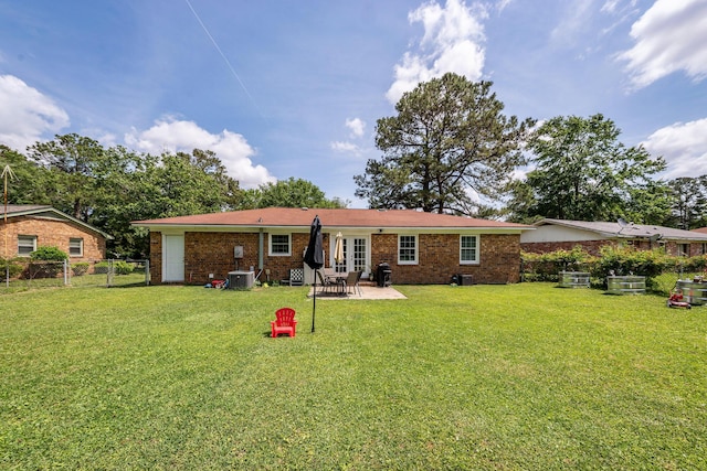 rear view of property with a lawn, a patio area, fence, and brick siding