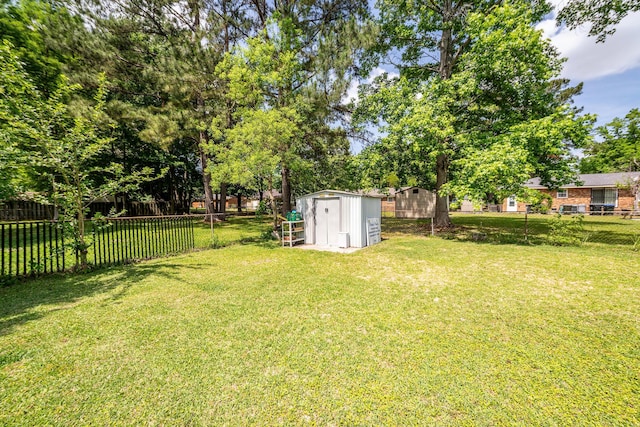 view of yard featuring an outdoor structure, a fenced backyard, and a storage shed