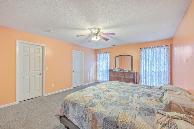 carpeted bedroom featuring ceiling fan and a textured ceiling