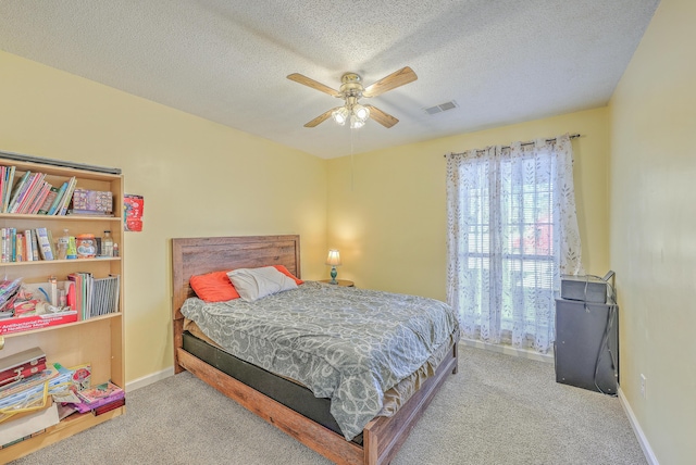 carpeted bedroom featuring a textured ceiling and ceiling fan