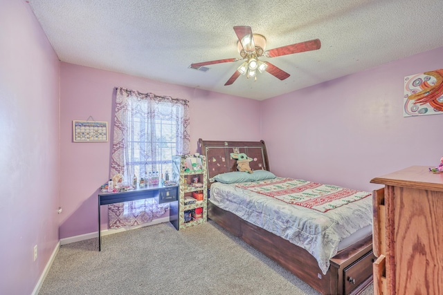 carpeted bedroom featuring ceiling fan and a textured ceiling