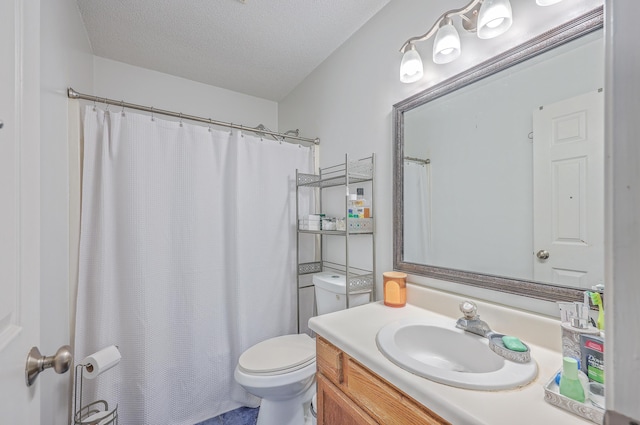 bathroom featuring a shower with curtain, vanity, toilet, and a textured ceiling