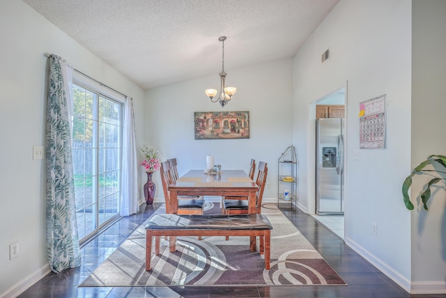 dining area with dark hardwood / wood-style floors, a chandelier, vaulted ceiling, and a textured ceiling