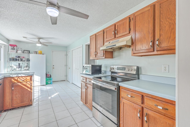 kitchen featuring ceiling fan, appliances with stainless steel finishes, a textured ceiling, and light tile patterned floors