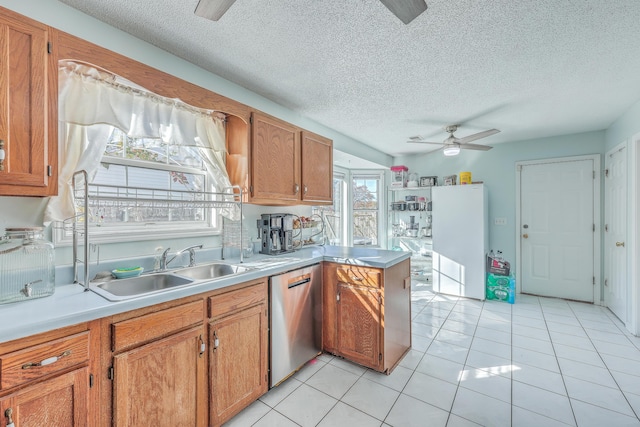 kitchen featuring light tile patterned floors, dishwasher, ceiling fan, a textured ceiling, and kitchen peninsula