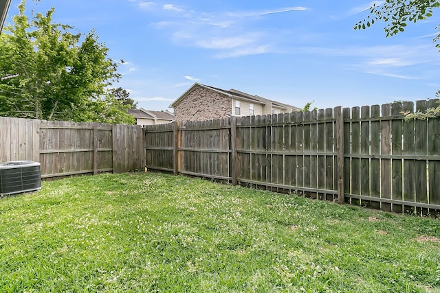 view of yard with a fenced backyard and central AC