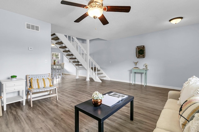 living room featuring visible vents, wood finished floors, and stairway