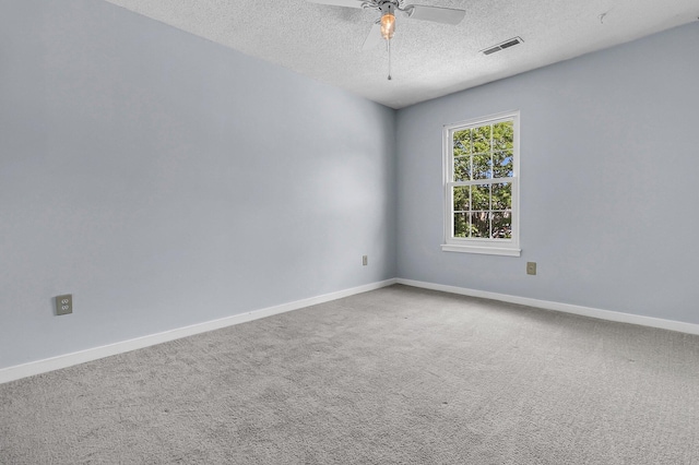 spare room featuring a ceiling fan, a textured ceiling, visible vents, baseboards, and carpet flooring