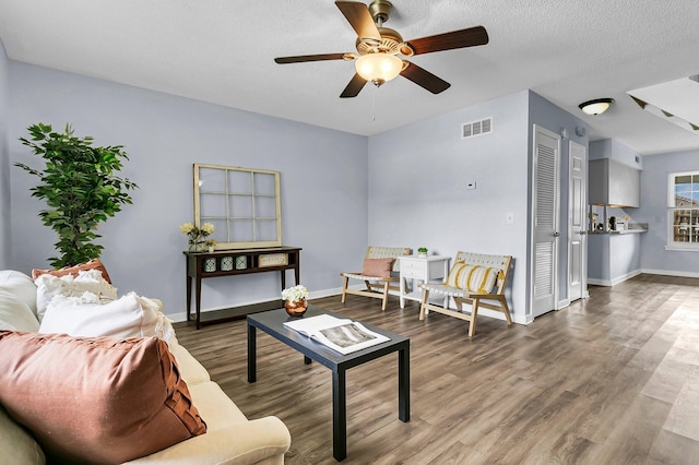 living room with a ceiling fan, baseboards, visible vents, and wood finished floors