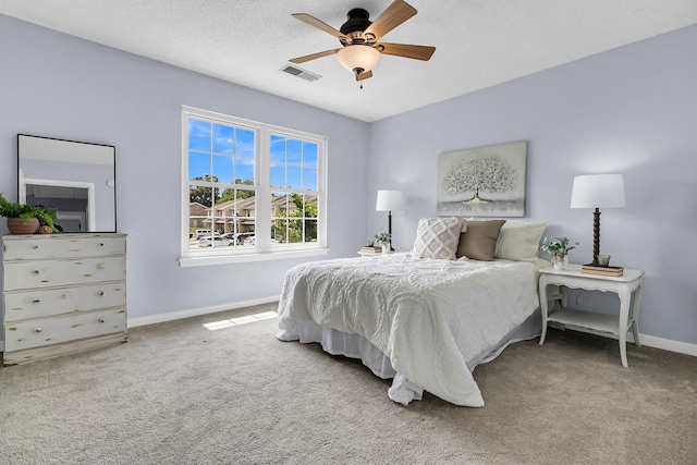 carpeted bedroom with baseboards, a ceiling fan, and visible vents