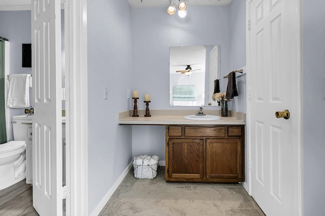 bathroom featuring vanity, a ceiling fan, baseboards, and toilet