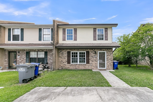 view of front of home featuring brick siding and a front yard