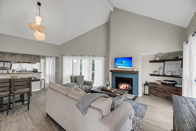 living room featuring high vaulted ceiling, beamed ceiling, and light hardwood / wood-style flooring