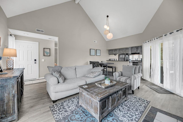 living room with high vaulted ceiling, hardwood / wood-style flooring, and beam ceiling