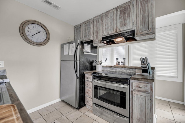 kitchen with light tile patterned floors, ventilation hood, and stainless steel appliances