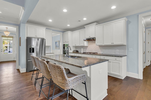 1325 Whisker Pole Ln, Mount Pleasant, SC 29466 - kitchen with stainless steel appliances, under cabinet range hood, a sink, dark stone counters, and tasteful backsplash