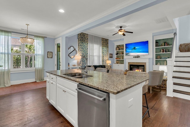 1325 Whisker Pole Ln, Mount Pleasant, SC 29466 - kitchen featuring dishwasher, a sink, a glass covered fireplace, an island with sink, and light stone counters