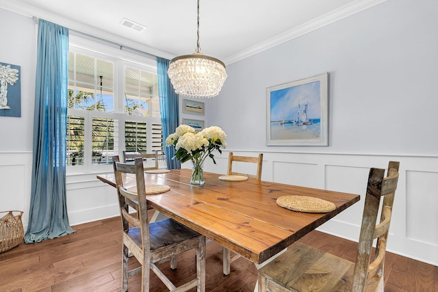 1325 Whisker Pole Ln, Mount Pleasant, SC 29466 - dining room with ornamental molding, a chandelier, a decorative wall, wood finished floors, and wainscoting